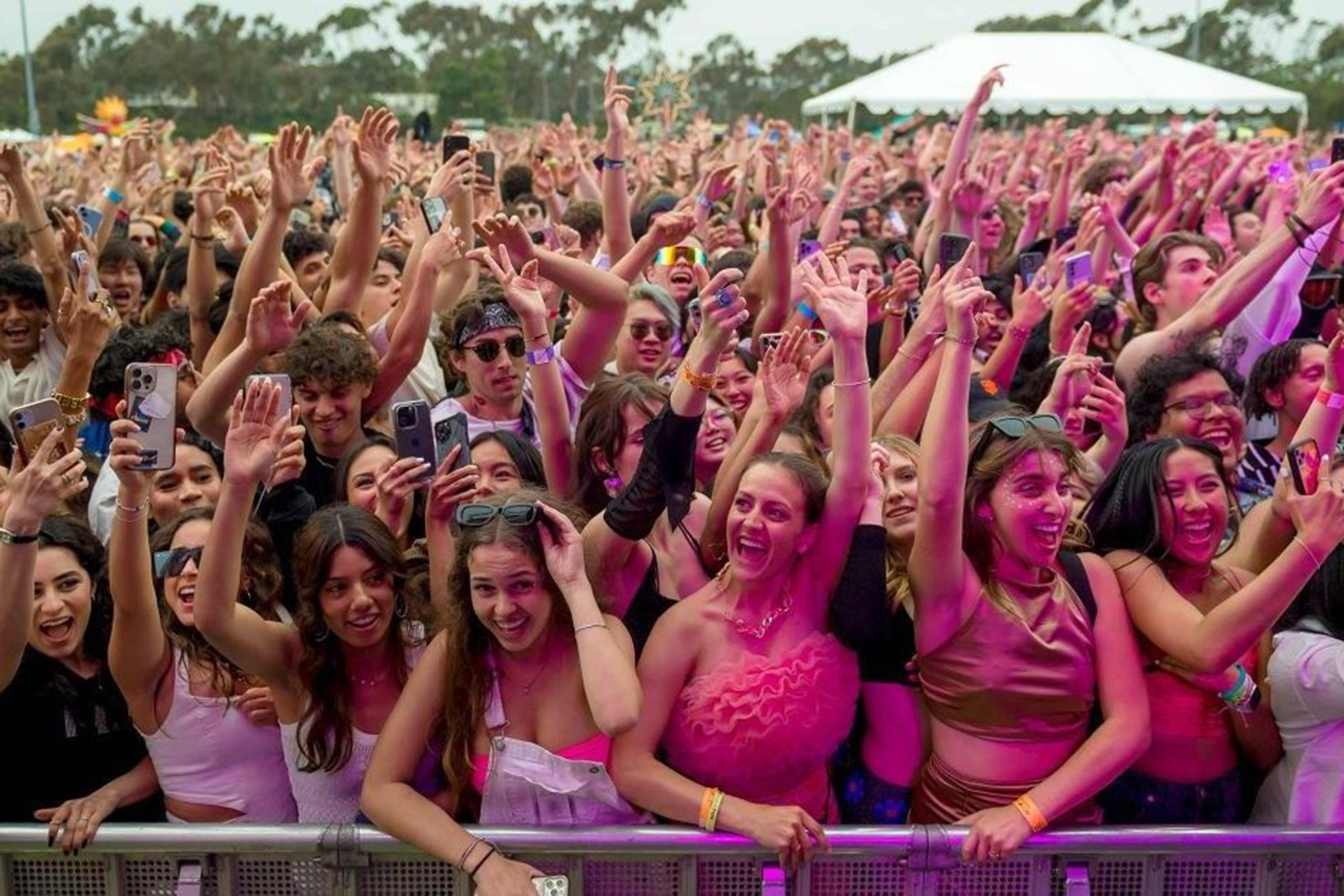 Large crowd of students with hands in air during concert